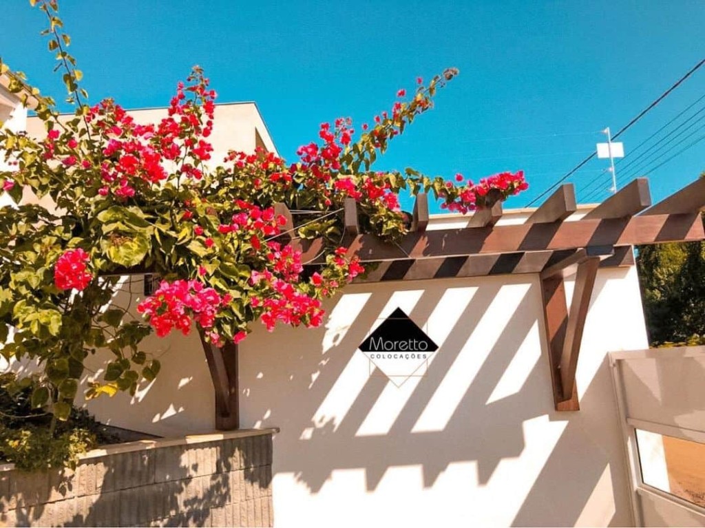 Pergolado de madeira com flores em varanda